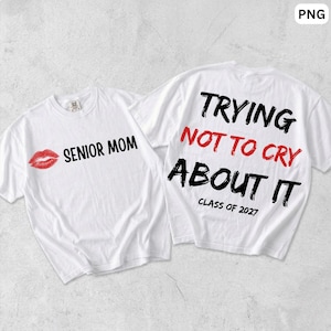 May include: Two white t-shirts. The left shirt features a red lip graphic and the black text SENIOR MOM. The right shirt features the black text TRYING, the red text NOT TO CRY, the black text ABOUT IT, and the black text CLASS OF 2027.