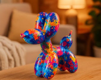 May include: A colorful balloon dog sculpture in shades of blue, orange, pink, and yellow. The dog is posed on a wooden surface. The sculpture has a glossy finish and is a decorative item.