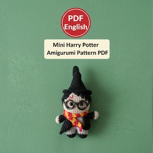 May include: A crocheted Harry Potter amigurumi doll, wearing a black hat, glasses, and a red and yellow scarf. The doll has a black robe and is standing on a green background. Text on the image reads "Mini Harry Potter Amigurumi Pattern PDF".