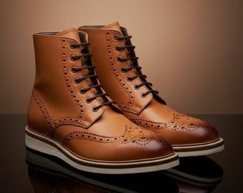 May include: A pair of tan leather boots with brogue detailing and black laces. The boots have a stacked sole with a white midsole and are set against a brown gradient background. The boots are a classic style.