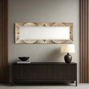 Può includere: Uno specchio rettangolare con una cornice dorata a motivi geometrici è appeso sopra un mobile marrone scuro. Una ciotola nera e dei libri sono sul mobile. Una lampada con paralume beige e base marrone scuro è sul mobile.