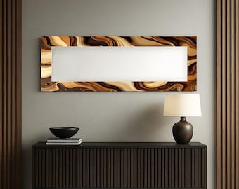 May include: A rectangular wall mirror with a white center and a decorative frame featuring swirling patterns in shades of brown, beige, and gold. The mirror is mounted on a gray wall above a dark brown cabinet. A lamp and a black bowl are also visible.