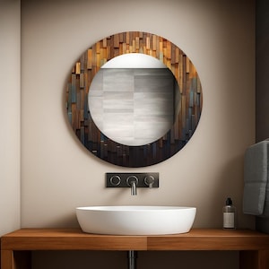 Può includere: Uno specchio da bagno rotondo con una cornice a mosaico in legno. La cornice presenta un mix di pezzi di legno marrone, grigio e blu. Sotto lo specchio un lavabo ovale bianco, un rubinetto nero e un piano di lavoro in legno.