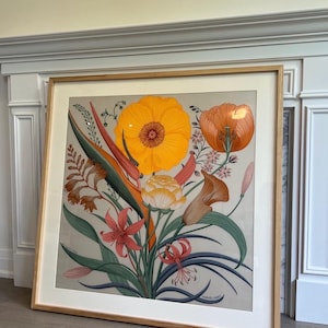 May include: A framed floral print featuring a vibrant bouquet of flowers in shades of orange, yellow, and red. The artwork includes a large, central orange flower and various other blooms and foliage. The print is set in a light wood frame.