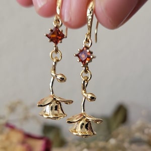 Pendientes colgantes de rosa romántica dorada con cristales inspirados en granates, florales, elegantes y femeninos.