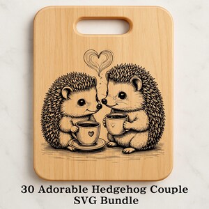 Könnte beinhalten: Ein helles Holzschneidebrett mit Griff, das eine Schwarz-Weiß-Illustration von zwei Igeln mit Kaffeetassen zeigt. Ein herzförmiger Wisp schwebt über ihnen. Der Text "30 Adorable Hedgehog Couple SVG Bundle" befindet sich unten.