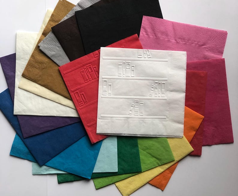 Puede incluir: Una pila de 15 servilletas de papel en varios colores, incluyendo rojo, azul, verde, amarillo y blanco. Las servilletas est&aacute;n dobladas por la mitad y tienen una superficie texturizada. Una servilleta tiene un dise&ntilde;o blanco en relieve con l&iacute;neas y cuadrados.
