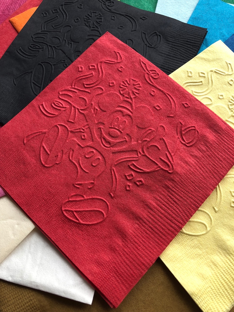 Pu&ograve; includere: Una collezione di tovaglioli di carta colorati, tra cui rossi, neri, gialli e blu. Il tovagliolo rosso presenta un disegno in rilievo di un personaggio dei cartoni animati. I tovaglioli sono quadrati e hanno una superficie strutturata.