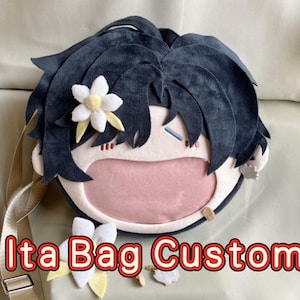 May include: A custom-made Ita Bag with a cartoon character design. The bag features a dark blue hair design, a pink mouth, and a beige strap. The text "Ita Bag Custom" is printed on the bottom of the bag.