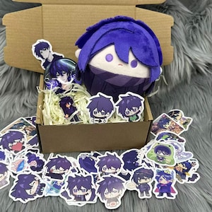 Puede incluir: Una mu&ntilde;eca de peluche con cabello azul y una bufanda a juego se encuentra en una caja de cart&oacute;n llena de pegatinas y papel de relleno. Las pegatinas presentan varios dise&ntilde;os de personajes de estilo anime en tonos morados y azules.