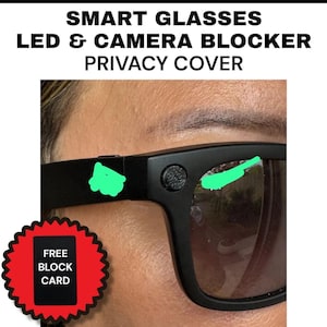 May include: Black smart glasses with the text "SMART GLASSES LED & CAMERA BLOCKER PRIVACY COVER." The glasses have a privacy cover and a free block card. The lenses are tinted and reflect the surrounding environment.