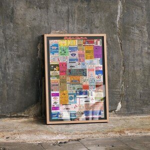 May include: A rectangular framed wall art piece featuring a collage of various colorful vintage tickets in shades of yellow, blue, pink, and green. The frame is light wood, and the top of the collage displays the red text St. Louis Cardinals.