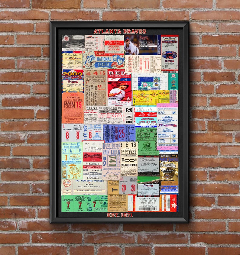 Op de afbeelding: Een ingelijste collage van vintage Atlanta Braves honkbaltickets en memorabilia met diverse data, stoelnummers en teamlogo's. De tekst ATLANTA BRAVES staat bovenaan en EST. 1871 onderaan in de zwarte rechthoekige lijst.