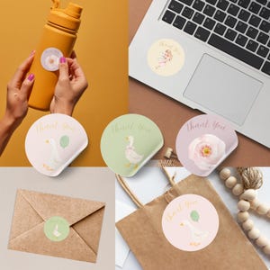 May include: A collection of round stickers with the words "Thank You" in gold script. The stickers feature illustrations of a fairy, a goose with a balloon, a goose with a bow, and a pink flower. One sticker is on a yellow water bottle.