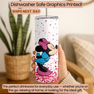 May include: A white tumbler with a Minnie Mouse design, featuring a pink bow, blue dress, and black details. The tumbler is decorated with small pink hearts and includes the text "Dishwasher Safe Graphics Printed!" and "SHIPS NEXT DAY".
