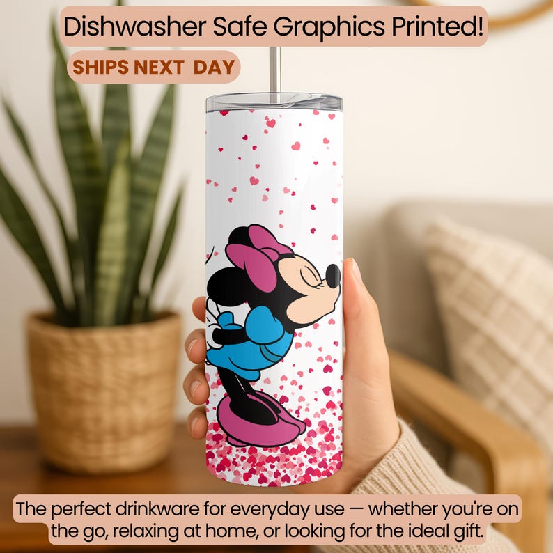 May include: A white tumbler with a Minnie Mouse design, featuring a pink bow, blue dress, and black details. The tumbler is decorated with small pink hearts and includes the text "Dishwasher Safe Graphics Printed!" and "SHIPS NEXT DAY".
