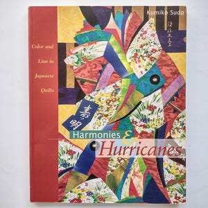 May include: A book titled Harmonies & Hurricanes: Color and Line in Japanese Quilts by Kumiko Sudo. The cover features a vibrant, multi-colored collage of fabric patterns in shades of red, yellow, blue, and green, with Japanese calligraphy.