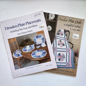 May include: Two instructional quilting books titled Dresden Plate Placemats including Tea Cozy and Pillow by Eleanor Burns and Dresden Plate Quilt a simplified method by Wendy Gilbert, both featuring photographs of finished quilted projects.