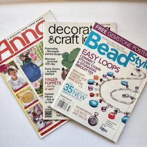 May include: Three magazines titled Anna, Decorating & Craft Ideas, and Bead Style are arranged in a fan shape. The covers feature various craft projects, including needlework, macrame, finger puppets, and jewelry making with colorful beads and chains.