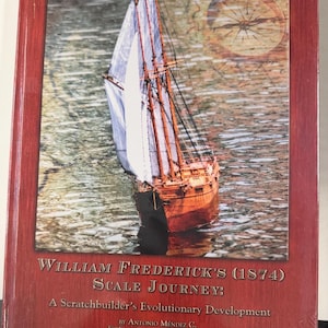 Könnte beinhalten: Ein gebundenes Buch mit dem Titel William Frederick's (1874) Scale Journey: A Scratchbuilder's Evolutionary Development von Antonio Méndez C. Das Cover zeigt ein hölzernes Segelschiff auf Wasser mit einem Kompass und einem dunkelroten Rand.