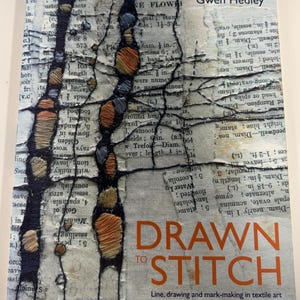 May include: A book titled Drawn to Stitch by Gwen Hedley. The cover features a collage of printed text pages overlaid with black thread embroidery forming branch-like structures and circular shapes filled with orange, yellow, and grey thread.
