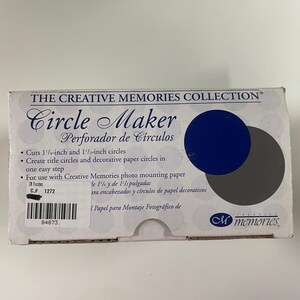 May include: A white box for a Circle Maker by Creative Memories. The box features the product name, "Circle Maker," in a decorative font, along with the text "Perforador de Circulos." It cuts 3.18 cm and 3.81 cm circles. The box has a blue and gray circle graphic.