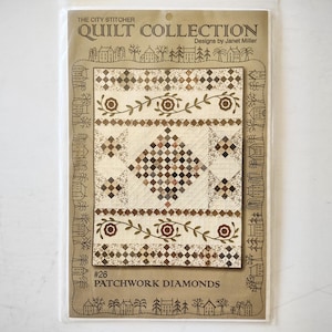 May include: A quilt pattern packet titled The City Stitcher Quilt Collection Designs by Janet Miller #26 Patchwork Diamonds. The cover features a brown and cream quilt design with diamond shapes, floral vines, and a border of small house illustrations.