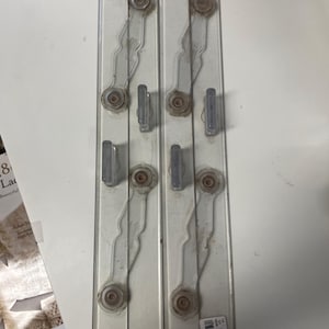 May include: Two clear plastic wall organizers with multiple hooks and decorative elements. Each organizer has a series of clear, curved supports and small, rectangular hooks. The organizers are designed to be mounted on a wall.