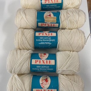 May include: Five skeins of off-white Pixie brand knitting yarn. Each skein has a blue label with the brand name, a mushroom graphic, and text that reads "100% Acrylic Knitting Worsted Weight". The yarn is shrink resistant and permanently mothproof.