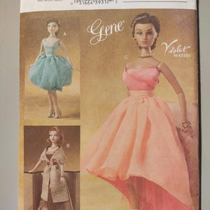 May include: Vogue Doll Collection pattern featuring three doll designs. The cover displays a doll in a pink dress with a high-low skirt, and two other dolls in different outfits. The pattern number is V8055.