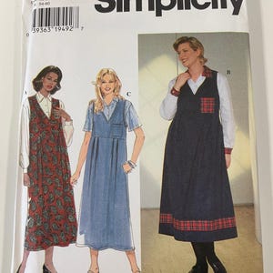 May include: A Simplicity sewing pattern envelope featuring illustrations of three different dress designs. The envelope includes the text "Simplicity" and the pattern number "7347". The dress designs include a paisley print, a denim-style dress, and a plaid-trimmed dress.