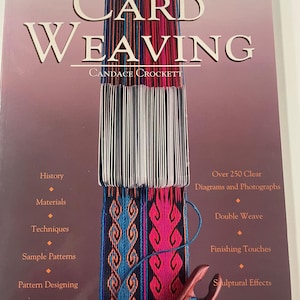 May include: The book "Card Weaving" by Candace Crockett, showing a colourful woven band in blue, pink, and white. The cover text includes topics such as history, materials, techniques, and sample patterns. The book contains over 250 diagrams and photographs.