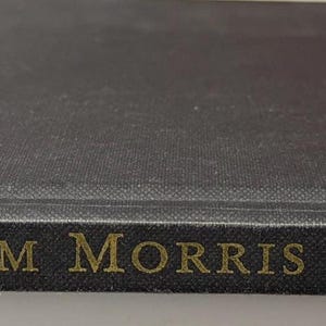 May include: A black hardcover book with gold lettering on the spine that reads Beth Russell's WILLIAM MORRIS NEEDLEPOINT and CROWN. The book is positioned horizontally, showing the front cover and the spine with clear, legible text.