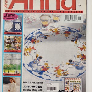 May include: The cover of "Anna" magazine, January 2003, features a colorful needlework project with a winter theme. The cover includes text such as "Creative Needlework and Crafts" and "Winter Pleasures". The main image is a round tablecloth with snowmen and penguins.