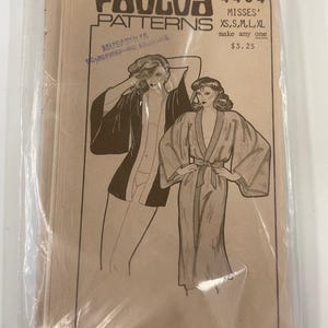 May include: A vintage Paula Patterns sewing pattern packet. The packet is tan with illustrations of women wearing robes. Text includes "PAULOA PATTERNS", "4404", "MISSES' XS, S, M, L, XL", and the address "211 Kona St. Honolulu, HI. 96814".
