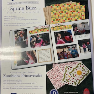 May include: A scrapbook kit labelled "Spring Buzz" with stickers and printed paper. The kit includes block sticker sheets, mini stickers, and 25.4 x 30.5 cm printed paper. The packaging features photos and the text "What's the buzz?" and "at the zoo?"