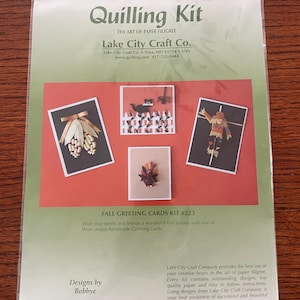 Könnte beinhalten: Ein Quilling-Set von Lake City Craft Co. für Herbstgrußkarten in einer transparenten Kunststoffverpackung. Die Verpackung enthält den Text Quilling Kit, The Art of Paper Filigree und Fall Greeting Cards Kit #223 sowie vier Papier-Quilling-Motive.