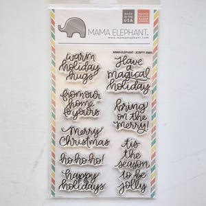 Pode incluir: Um conjunto de carimbos de fotopolímero transparente da Mama Elephant intitulado Scripty Xmas. O pacote contém várias frases temáticas de feriado em escrita cursiva, incluindo warm holiday hugs, have a magical holiday, from our home to yours, bring on the merry, Merry Christmas, ho ho ho, happy holidays e tis the season to be jolly.