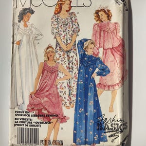 May include: A vintage McCall's sewing pattern envelope featuring illustrations of women's sleepwear designs. The envelope displays various styles, including a long white robe, floral pajamas, and a blue floral nightgown. The text "Fashion Basics" is visible.