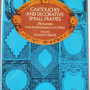 Op de afbeelding: Boekomslag met de titel "CARTOUCHES AND DECORATIVE SMALL FRAMES" op een blauwe achtergrond. Het toont zwarte frame-ontwerpen en bevat 396 voorbeelden van de Renaissance tot Art Deco, bewerkt door Edmund V. Gillon, Jr.