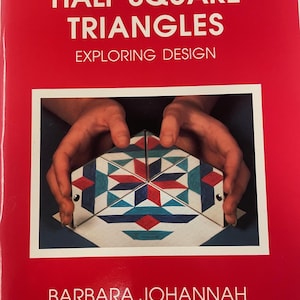 May include: A red book cover with the title "HALF SQUARE TRIANGLES" in white. The subtitle reads "EXPLORING DESIGN." The cover features a photo of hands holding a geometric design with red, blue, and teal shapes. The author's name, "BARBARA JOHANNAH," is at the bottom.