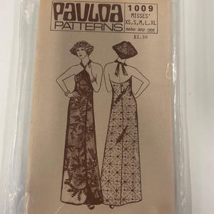 May include: A vintage Paulaa Patterns sewing pattern packet for Misses' dresses, size XS to XL. The packet features illustrations of two long dresses and includes the text "1009 MISSES'" and "make any one". The address 1649 Kapiolani Boulevard Rm 35 Honolulu, Hawaii 96814 is also visible.