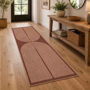 Peut inclure: Un long tapis de couloir rectangulaire présentant un fond rouge terre cuite profond avec un motif répétitif d'arcs concentriques de couleur crème. Le design se compose de fines lignes parallèles formant des motifs géométriques arrondis.
