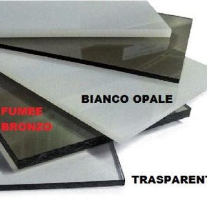 Può includere: Una pila di campioni di vetro in vari colori, tra cui bianco, grigio e trasparente. Le etichette di testo includono "BIANCO OPALE", "FUMEE BRONZO" e "TRASPARENTE". I fogli di vetro rettangolari sono probabilmente per scopi architettonici o di design.