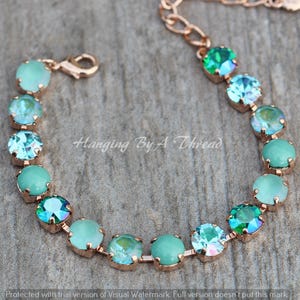 May include: A rose gold bracelet with a series of round, aquamarine gemstones. The bracelet has a delicate chain and clasp. The text "Hanging By A Thread" is visible on the image.