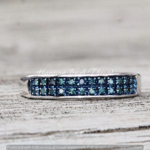 May include: A silver band ring with two rows of blue diamonds.