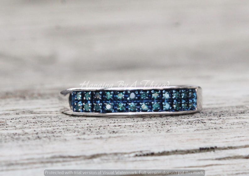 May include: A silver band ring with two rows of blue diamonds.