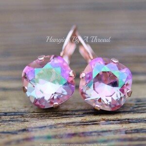 May include: Rose gold earrings with iridescent pink square-shaped crystals. Hanging By A Thread.