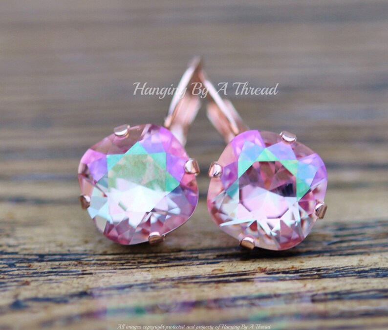 May include: Rose gold earrings with iridescent pink square-shaped crystals. Hanging By A Thread.