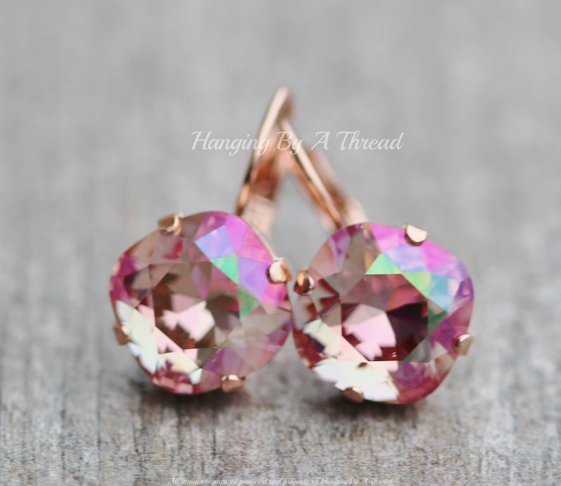 May include: Rose gold dangle earrings with pink iridescent crystal stones. Hanging By A Thread.